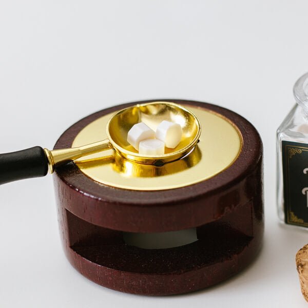 Siegelwachs Löffel auf Stövchen beim Schmelzen von Siegelwachs Perlen